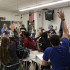 The members of Science Olympiad vote on whether to spend their fundraised money on T-shirts or save it for later use. The vote to save the money won.
