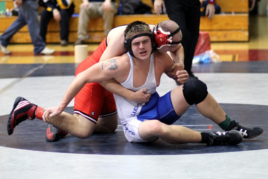 Devin Lundin (12) struggles to break free from his opponent. Lundin finished fifth at the 195 weight class.