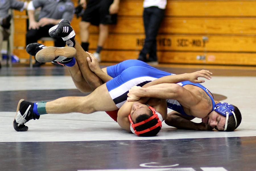 Jacob Sebahar (12) tries to pin his opponent. Sebahar finished second at the 145 weight class.