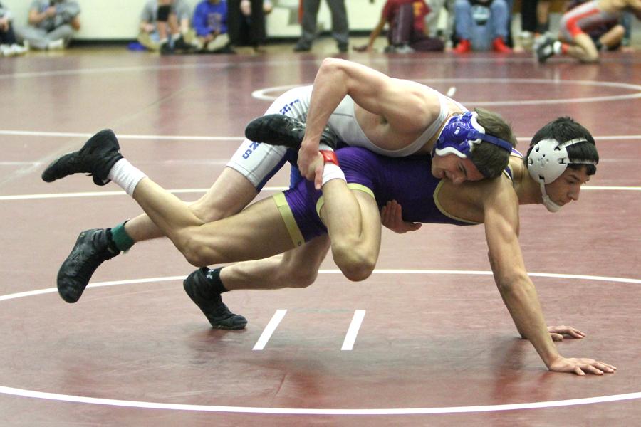 Nicholas Taylor (11) grabs his opponent’s ankle to keep him from escaping. Taylor did not end up advancing to Semi-State.