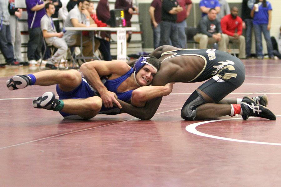 Jacob Sebahar (12) attempts to take control and reverse his opponent. Sebahar finished second in his bracket.