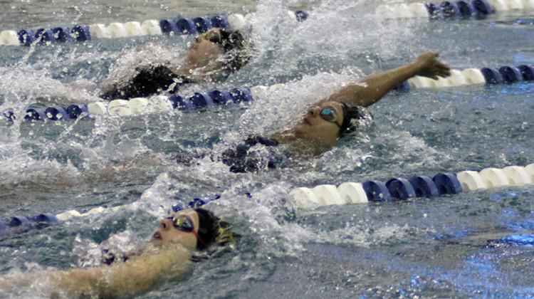 Marina Vasquez (12) goes head-to-head with with two Penn swimmers. Vasquez was swimming the 100 backstroke.