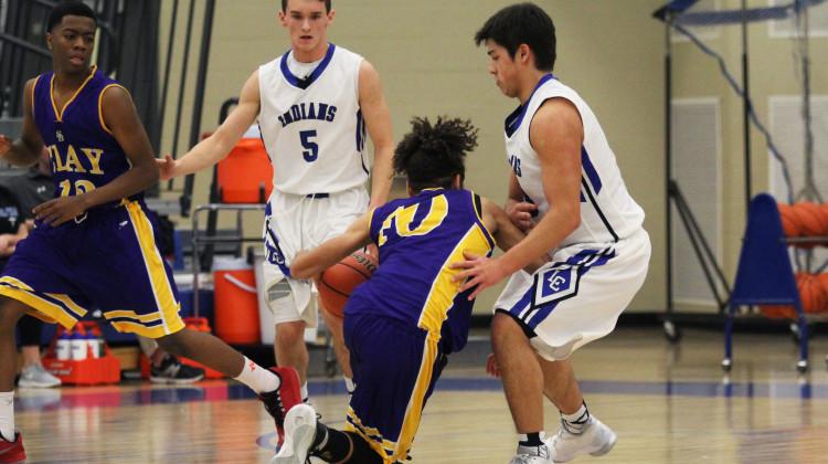 Conner Tomasic (10) and Justin Graciano (10) guard their opponent. The opposing player from Clay High School, Rashad Warfield (10), played both forward and guard throughout the game.