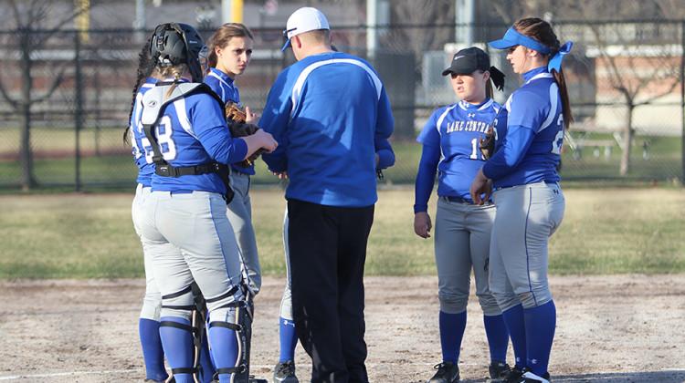 Varsity players strategize with Coach Jeff Sherman, Math. The team beat Munster 9-3.