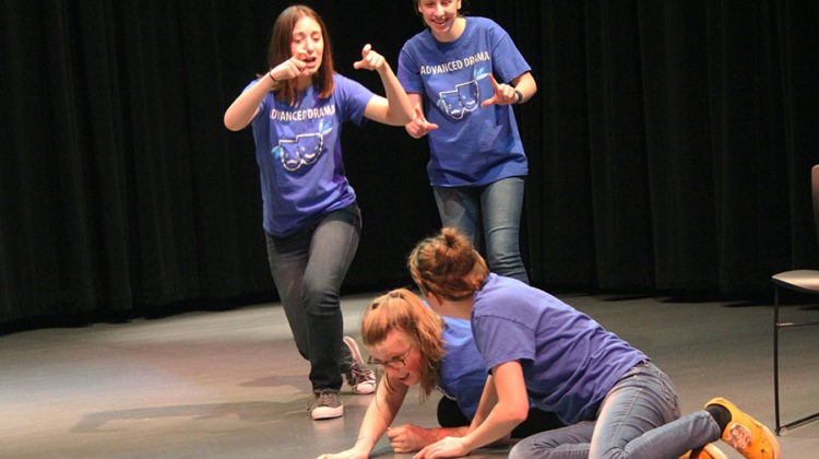 Alexa Spasevski (11) and Megan Paluszak (11) take pictures of Stephanie Gustas (10) and Evelyn Reder (12) in the skit “Dog and Cat.” Gustas and Reder acted as dogs who later rose up to turn their owners into cats.