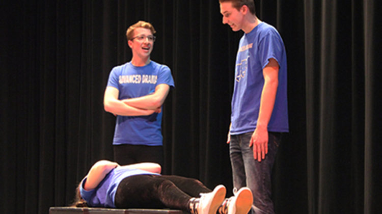 Adam Gustas (12) and William Kruzan (12) stand over the body of their local mailman, Hannah Souronis (12). At the end of the skit Souronis hopped out of her casket and walked right out the door.