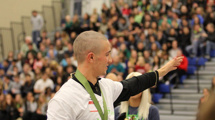 Nicholas Lucas (12) waves to the crowd after getting his head shaved. The assembly took place on March 17.