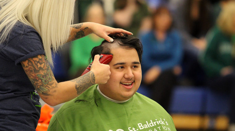 Collin Elliot smiles as gets his head shaved. He was a survivor of the fight through cancer.