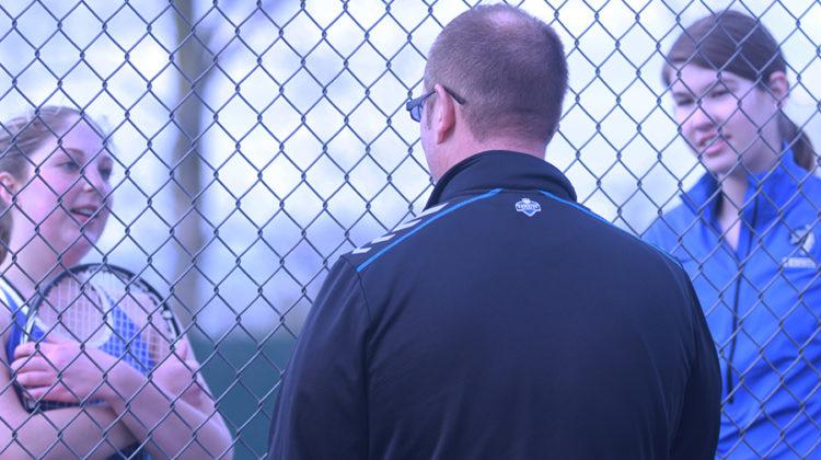 Kaitlin George (12) and Colette Oboy (11) listen to their coach’s advice for the next play. The girls were able to successfully win their match.