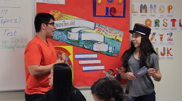 Theodore Mantis (10) tells Autumn Flenar (10) the significance behind the French police hat she is wearing. Flenar won the prize of wearing the hat for the duration of the meeting after being the first to complete a crossword puzzle.