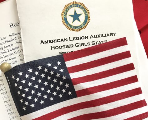 A program from Hoosier Girl’s State is displayed with an American flag. The government camp at Trine University emphasized a love for God and country.