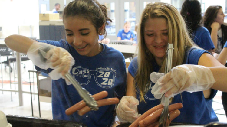 Frida Arellano (10) and Jade Mehock (10) prepare hot dogs for lunch. Arellano and Mehock were volunteers at the rush.