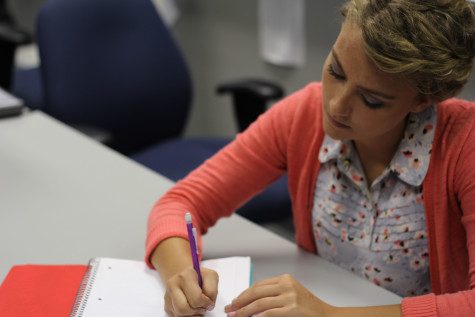 Erica Keleman (12) takes notes at school. She tried to finish as much of her homework as possible during school so she would not have to do it after babysitting.