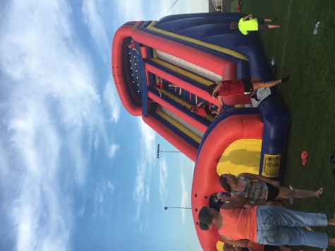 A bouncy house is being used by children at the block party. The block party took place after the parade. 