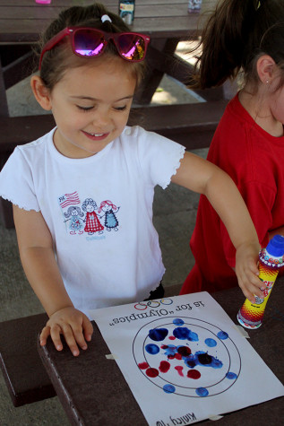 The young girl is coloring with markers at Kiddy Kamp. Kiddy Kamp was held from 10:30 a.m till 12 p.m.