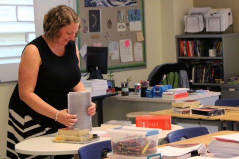 Mrs. Kathryn Clark, English, organizes a stack of handouts for parents. Her class was full of many of parents eager to learn about what their students would be covering in the course.