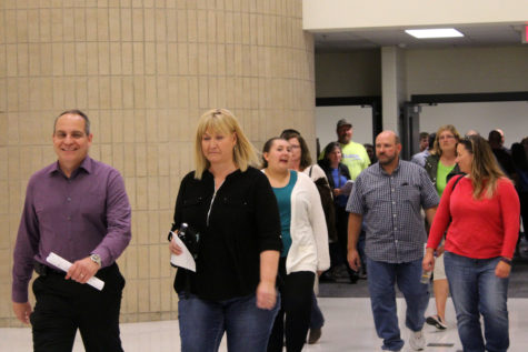  Parents pour out of classrooms as the bell rings to release them to the next class they need to go to. They eagerly chattered amongst themselves about the teachers they had already met and about the teachers they had yet to meet. 