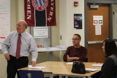 Mr. Kendal Smith, Science, gives informational handouts to parents and prepares to give a presentation about his class. He enthusiastically walked around the room and talked and met with parents to get to know them better.